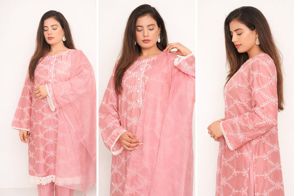 Woman wearing a pink traditional outfit with white patterns on a white background.