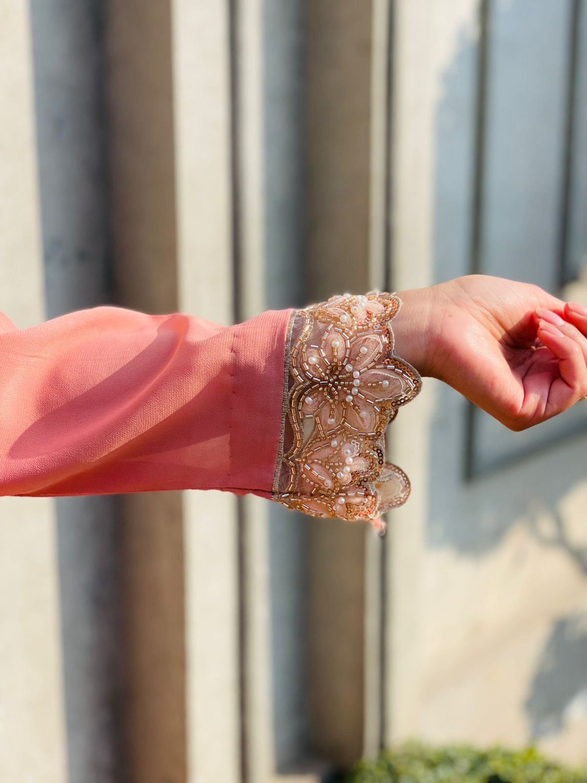 Close-up of a hand wearing a decorative bracelet with a blurred background