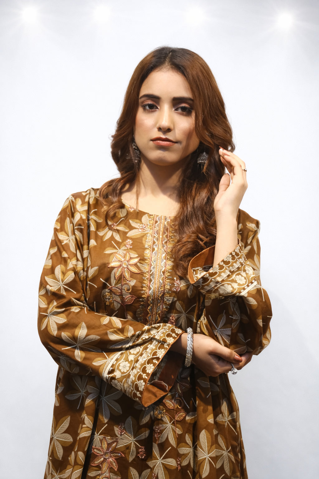 Woman wearing a brown floral patterned dress against a white background