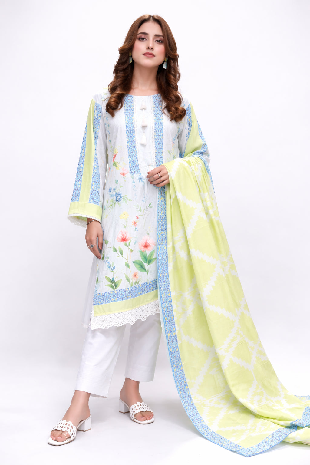 Woman wearing a white outfit with floral patterns and a yellow dupatta on a white background