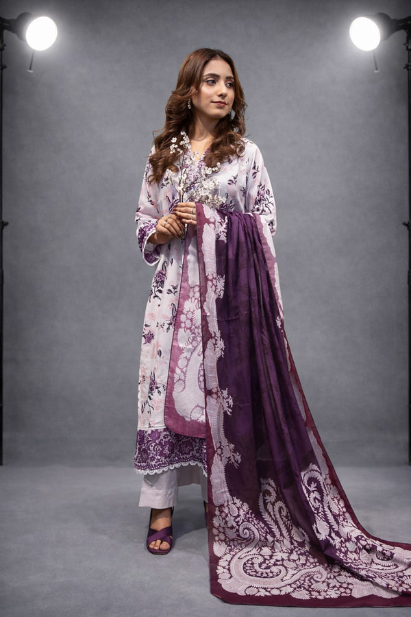 Woman wearing a white and purple traditional outfit with a matching dupatta against a gray background