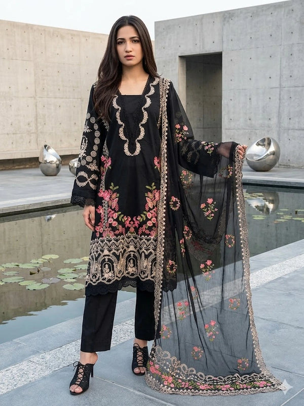 Woman wearing a black embroidered outfit with a sheer dupatta in an outdoor setting.