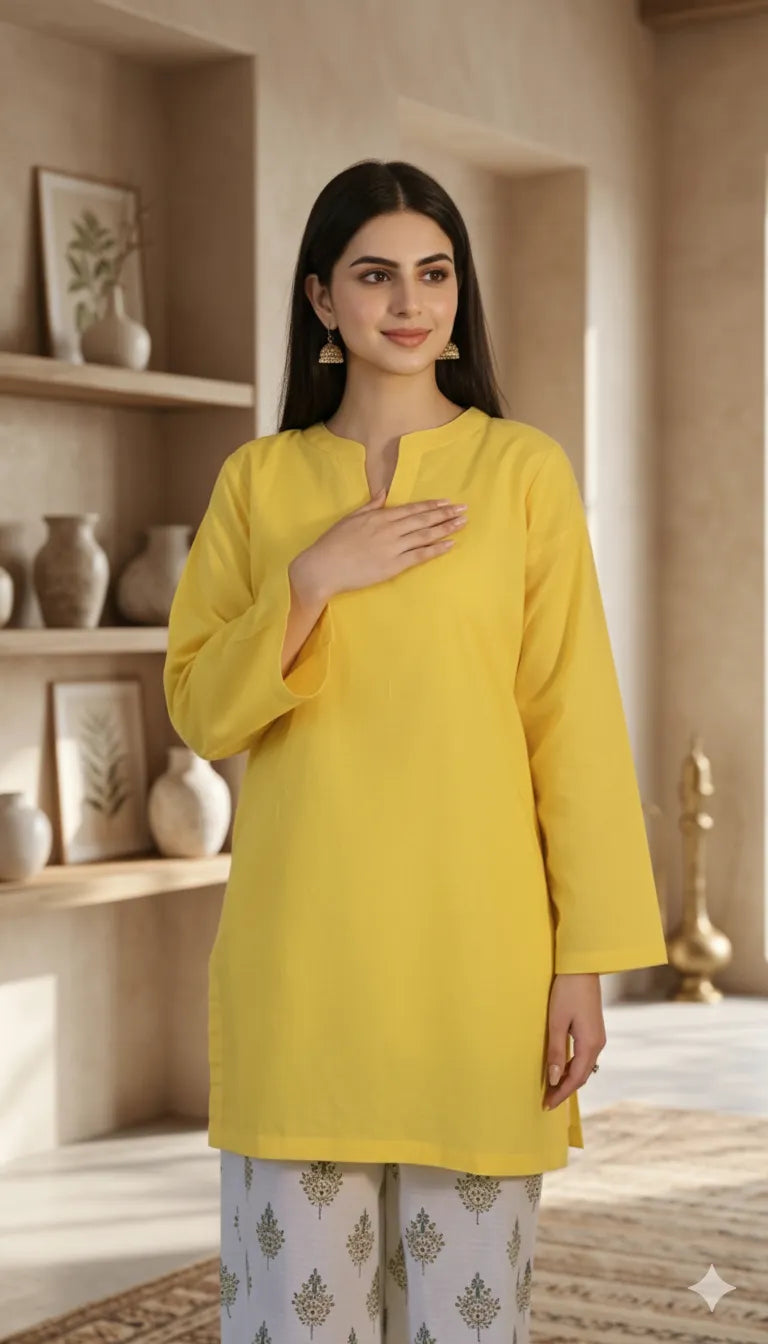 Woman wearing a yellow kurta in a home setting with decorative shelves.